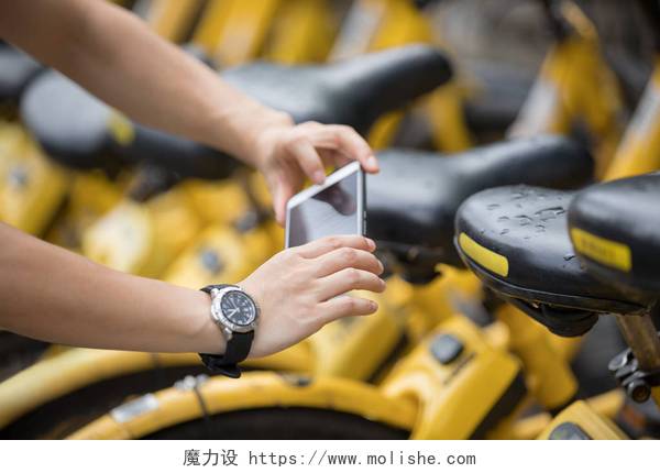 拿手机扫共享单车二维码的女性城市中使用智能手机和扫描共享自行车Qr代码的妇女的手